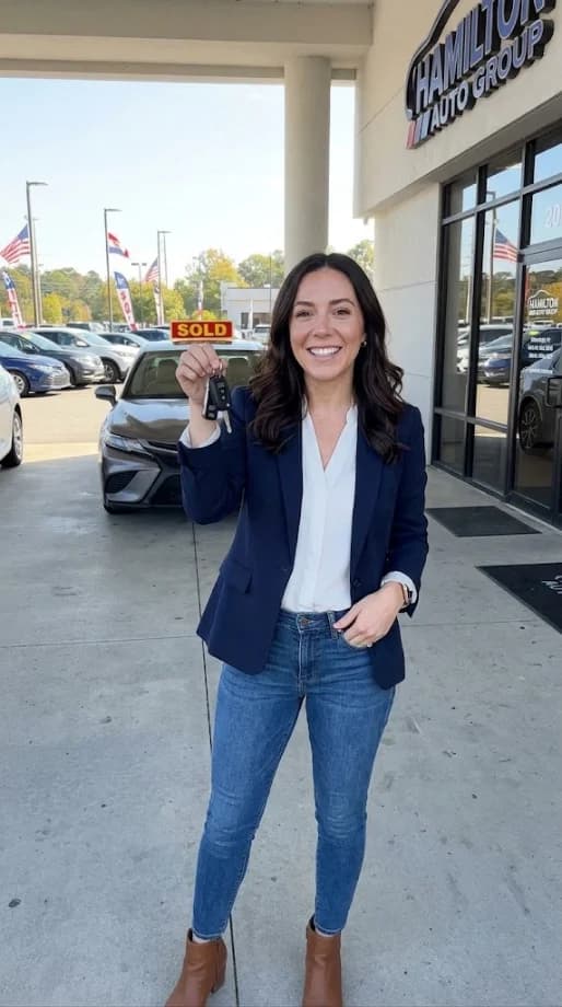 Woman holding car keys outside a dealership